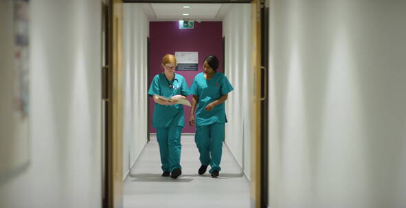 两个医务人员在医院走廊里行走
