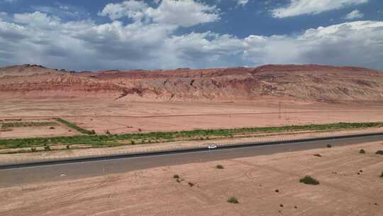 新疆火焰山荒凉沙漠中公路上的一辆车