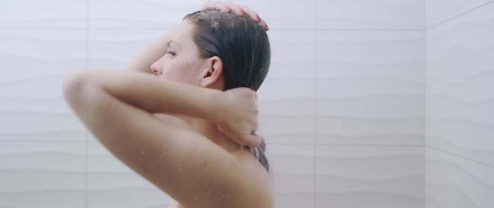 洗澡的女人在头发上擦洗发水