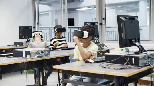 儿童坐在教室里使用虚拟现实眼镜