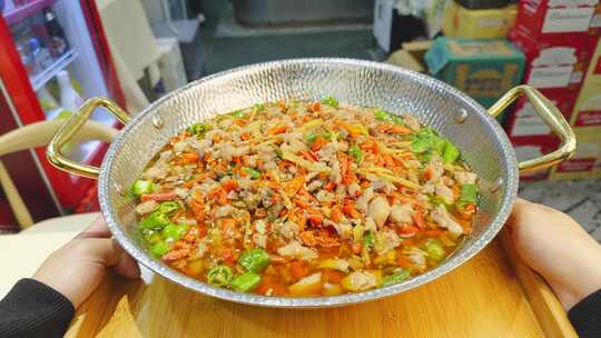 双手端特色炒菜锅素材