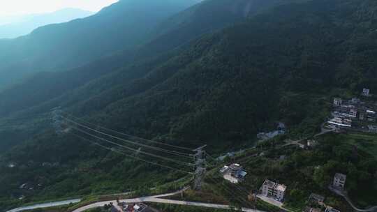 航拍群山间的变电站与高压电力铁塔输电线路