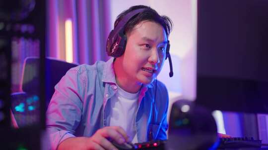 亚洲有吸引力的电子竞技男性游戏玩家在电脑上玩在线视频游戏。