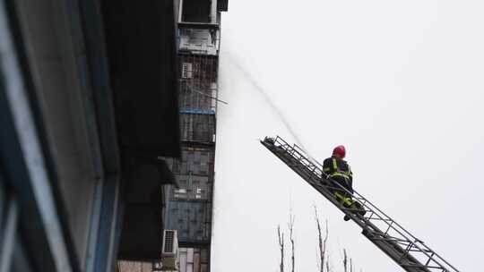 消防队员在高空梯梯上扑灭多层住宅大楼大火