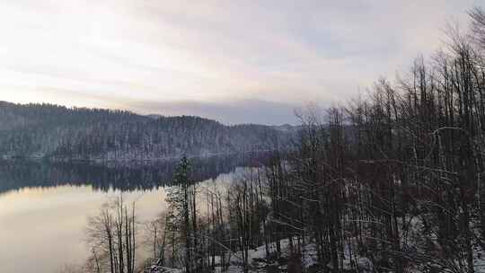 日落时平静的冬季湖泊倒影的照片