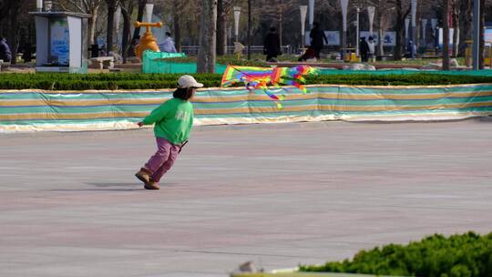 小女孩在公园空旷的广场上放风筝视频素材模板下载
