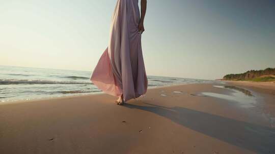 女人赤脚走在湿沙滩上