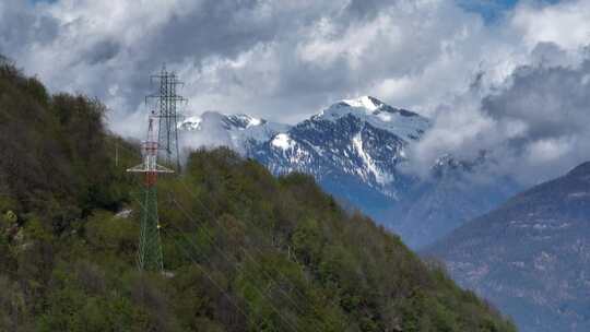 阿尔卑斯山山顶上的电力线塔，风景秀丽的尖山背景