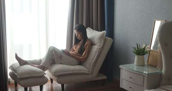 女子在室内沙发上休闲阅读