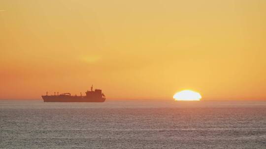 夕阳下的海上货船