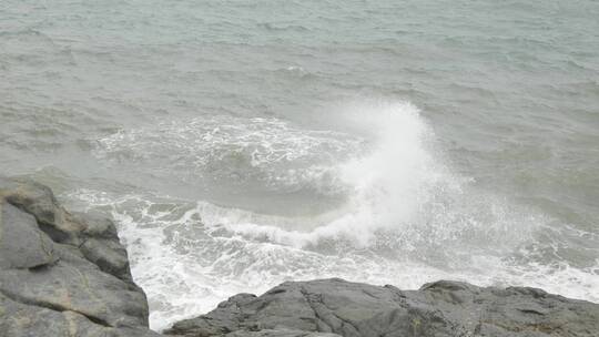 海边浪花拍打礁石，沙滩