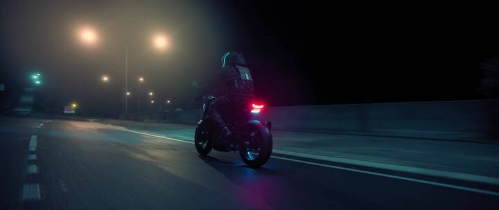 夜晚摩托车手在公路上骑行  