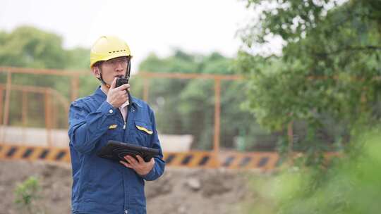 大桥建设工地工程师拿着平板电脑对讲机工作