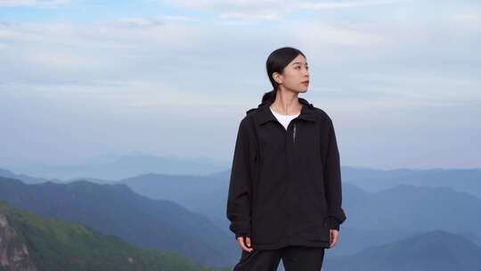 女性青年站在山顶看风景