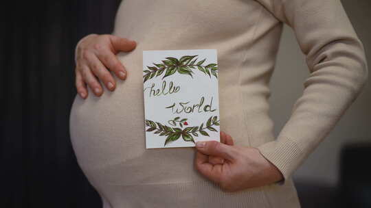 一个无法辨认的孕妇拿着生日贺卡摩擦的慢动