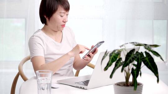 在家办公使用移动电话的亚洲女性