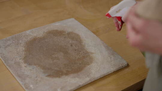 用手在陶器工作面上撒干粘土粉，为陶瓷成型