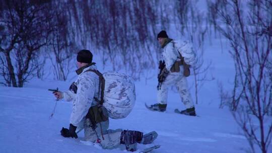 挪威陆军士兵在冬季雪地里使用滑雪板和雪地摩托练习地面战术
