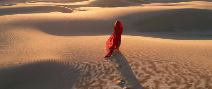 航拍沙漠中的红衣女子