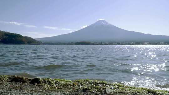 富士山与湖泊距离的低角度视图和海滩上的小波浪