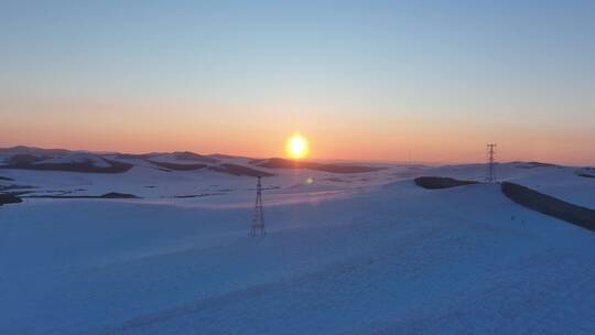 冬天丘陵地带雪域夕阳输电线路