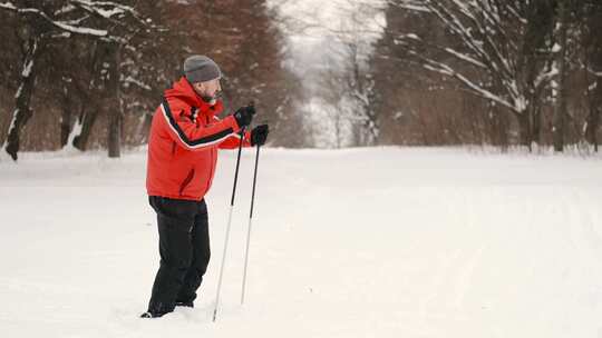 一男一女拿着登山杖在雪地里行走