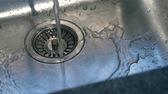 水龙头的水流掉入洗碗槽