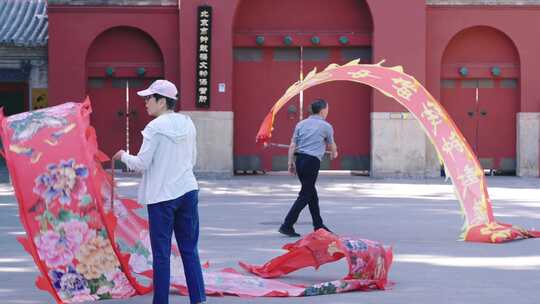 北京早晨舞彩带龙的老年人市民