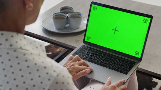 在带有绿屏显示器的笔记本电脑上工作的人