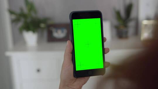 手持绿幕的女子手机轻拍屏幕视频素材模板下载