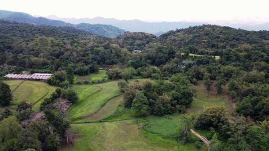 空中无人驾驶飞机向后移动，在坦普拉-帕苏埃北部美丽山脉上的小屋上空射击