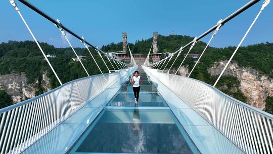 4K航拍张家界大峡谷玻璃桥上男人跑步视频素材模板下载