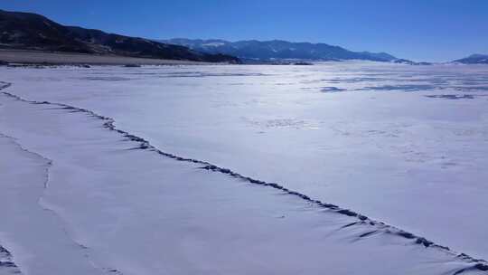 航拍新疆冬季赛里木湖冰封湖面雪山冰湖积雪