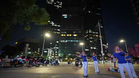 夜晚城市广场上人们跳广场舞的场景