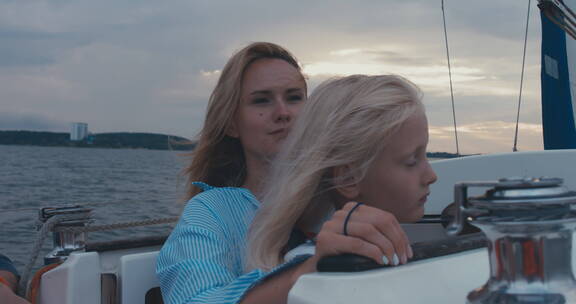 女儿和妈妈站在帆船上看风景