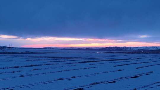 航拍浓郁夕阳下的垦区雪原