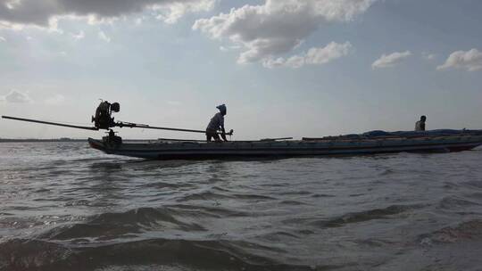湖上推木船的渔民剪影
