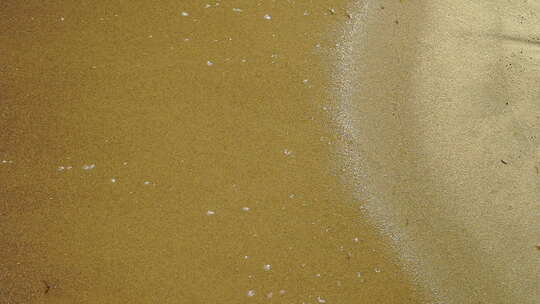 慢动作，观海岸边，泡沫从水中倒入沙子，沙子和水在煤上