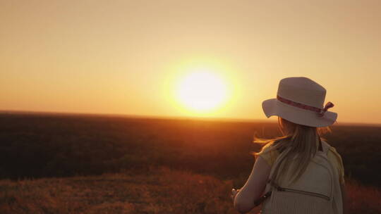 日落时分戴着草帽的女孩跑下山