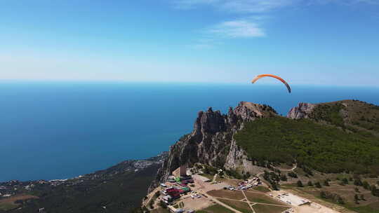 在美丽山峰的背景下，滑翔伞在滑翔伞上飞行