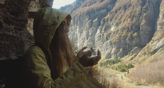 女人在山洞里张开双手感受落雨