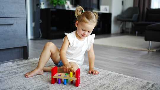 可爱的高加索小女孩在家里玩生态木制玩具