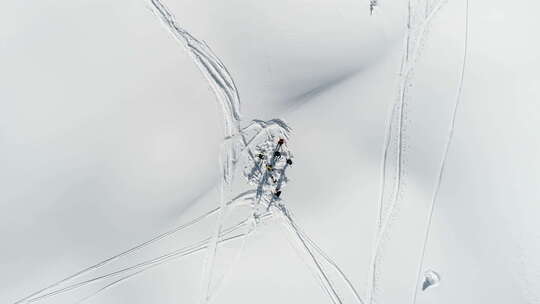 滑雪者在积雪覆盖的山上向上扔雪