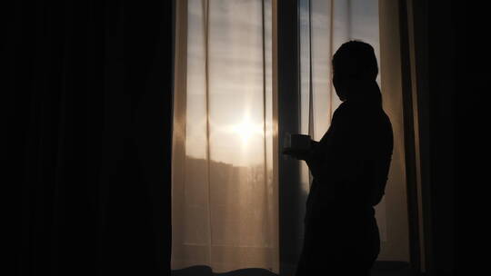 女人站在窗帘边喝咖啡视频素材模板下载