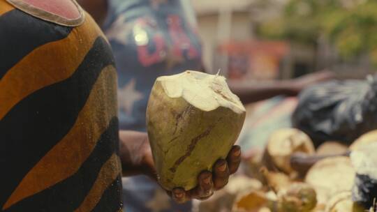 在街边小摊贩里买椰子的妇女