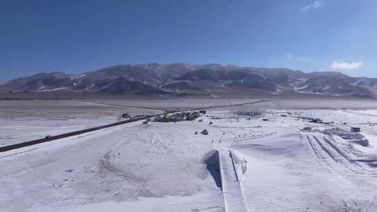 航拍新疆冬季赛里木湖冰封湖面雪山冰湖雪景