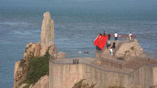 山东荣成成山头的游客与国旗