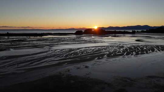 太阳带着沙子和岩石落在海洋上