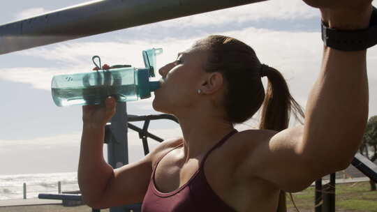 女人在户外健身运动完喝水