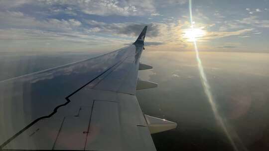 从飞机窗户看机翼和天空